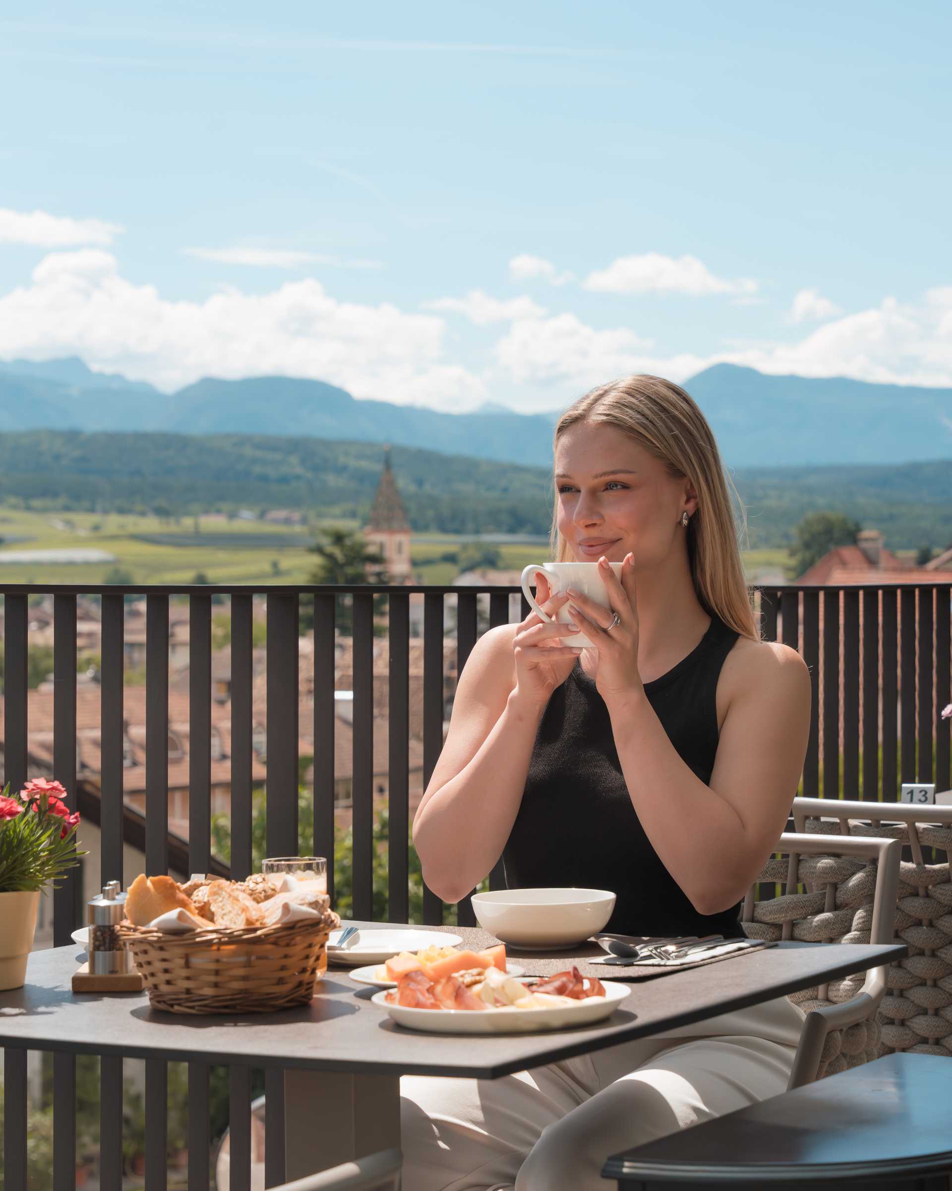 A lady is having breakfast on the sun terrace.