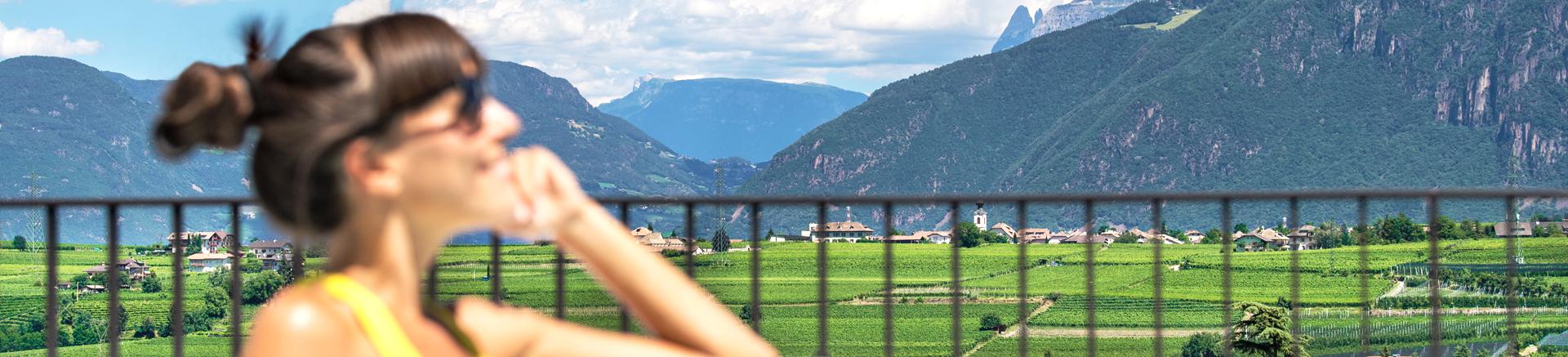 Una donna di fronte alla splendida vista panoramica dell'Hotel Christof ad Appiano