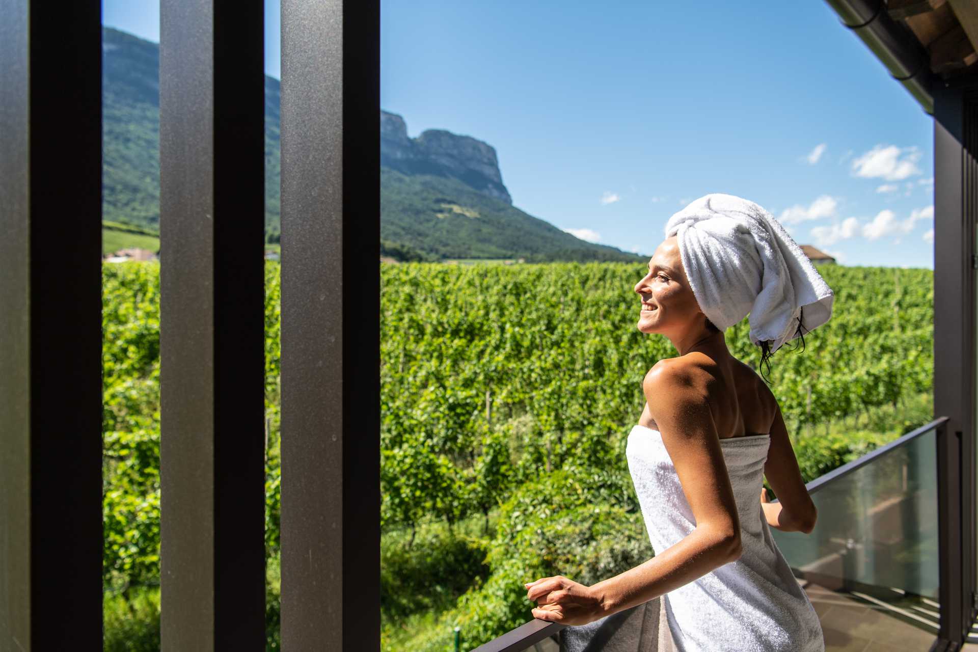 Sole pomeridiano sul lato ovest Una donna osserva i vigneti e si gode il sole.