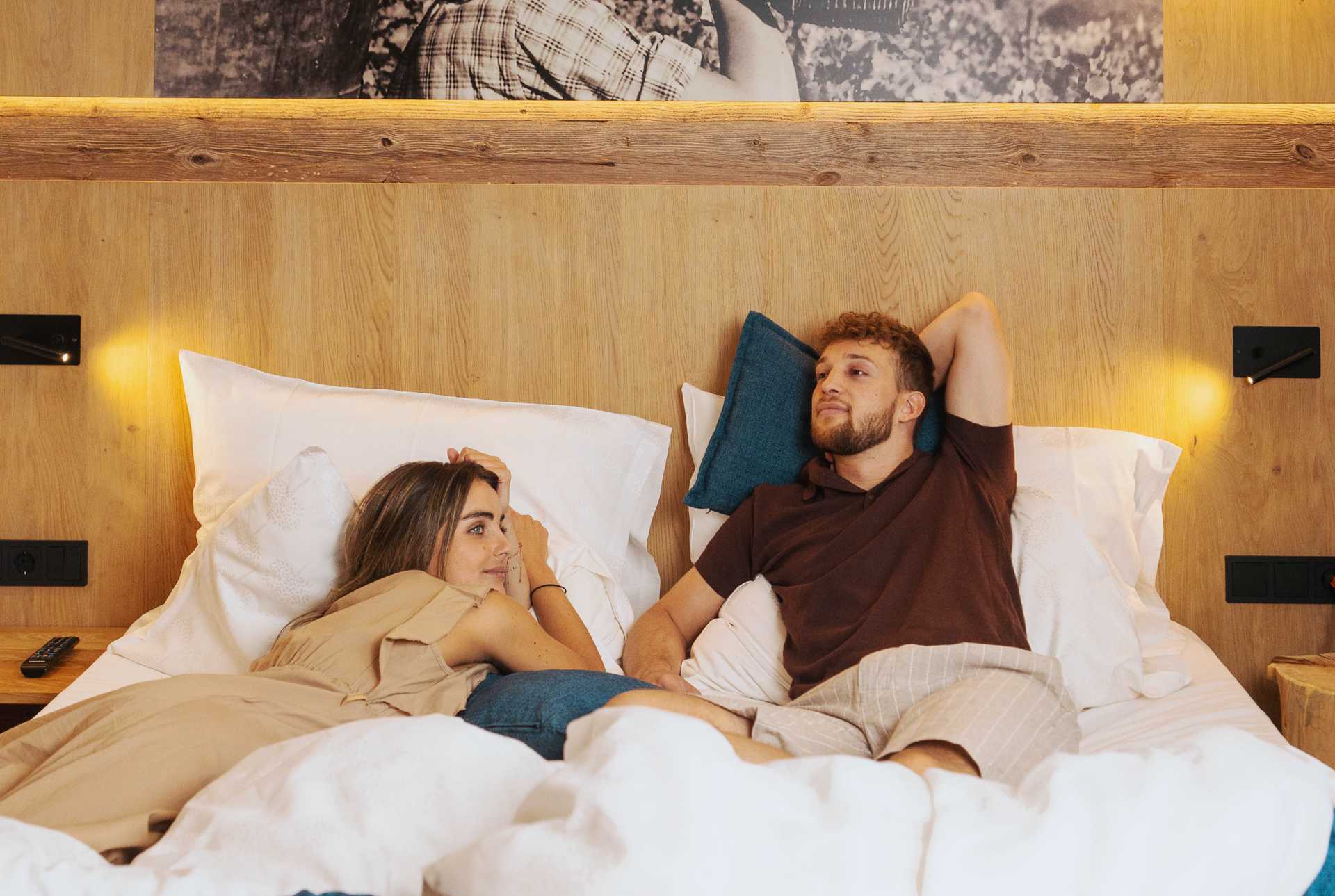 Just to doze off and daydream for a bit Two vacationers relax completely in bed
